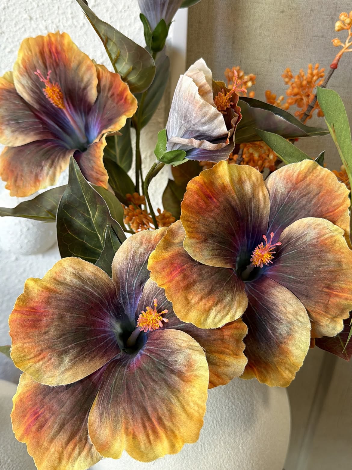 Arranjo de flores artificiais em tons quentes