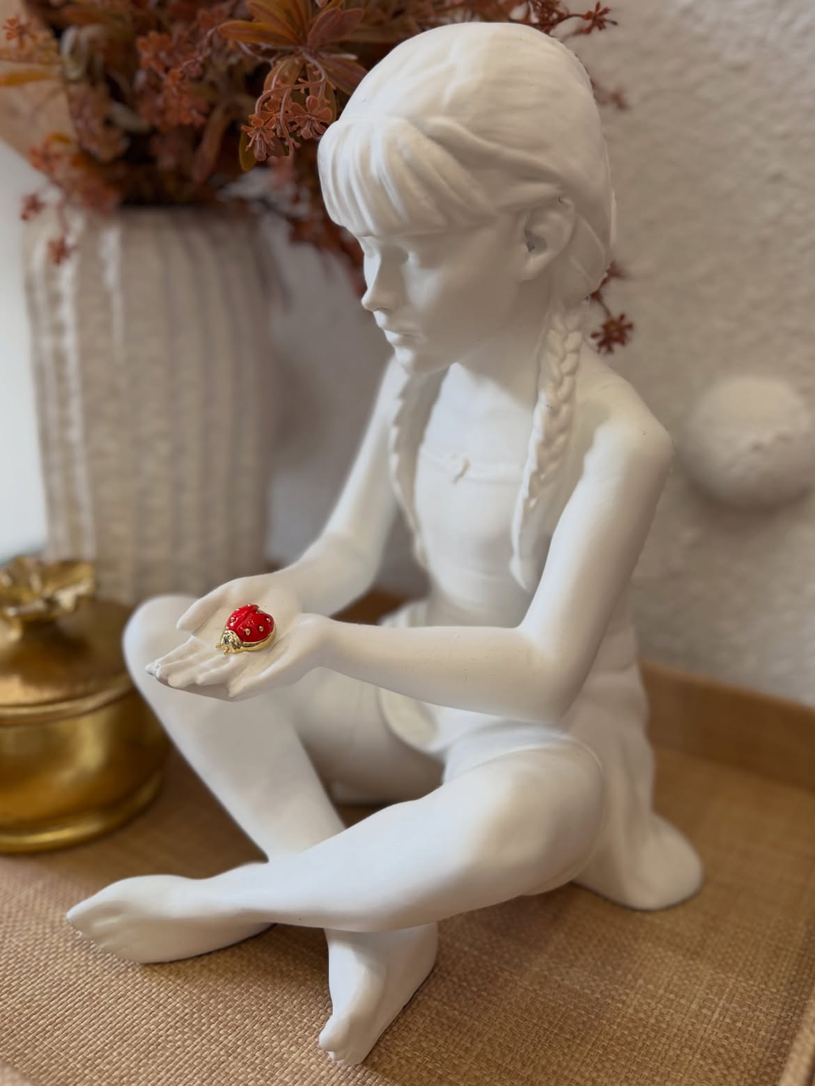 Escultura decorativa de menina com joaninha